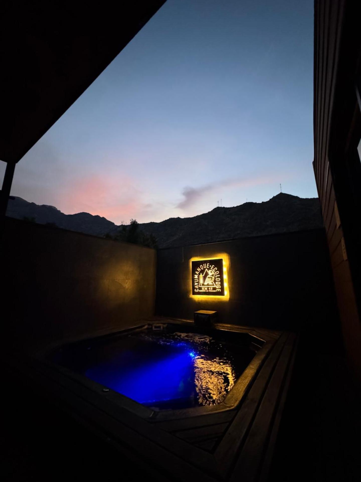 Piscina-jacuzzi iluminada al caer la tarde